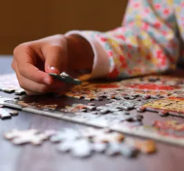 person putting together a jigsaw puzzle