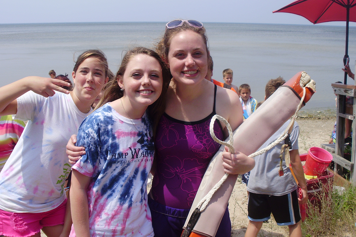 decfdb1f76a83e7c3bba7d6040e5b2dd Children playing basketball in a gym, with two players in red jerseys jumping to reach the ball and two others in purple jerseys actively participating. The YMCA logo is visible in the background, highlighting the community sports environment.
