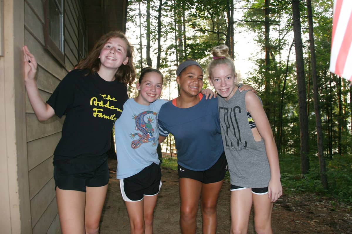 decfdb1f76a83e7c3bba7d6040e5b2dd Children playing basketball in a gym, with two players in red jerseys jumping to reach the ball and two others in purple jerseys actively participating. The YMCA logo is visible in the background, highlighting the community sports environment.